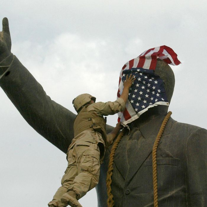 Baghdad, IRAQ: TO GO WITH AFP STORIES ON ANNIVERSARY OF THE FALL OF BAGHDAD: (FILES) A US Marine covers the face of Iraqi President Saddam Hussein's statue with the US flag in Baghdad's al-Fardous square 09 April 2003. The world was stunned when iconic images of US marines and Iraqis pulling down a statue of Saddam Hussein flashed across television screens. The toppling of the statue was immediately seized on as symbolising the overthrow of one of the world's most notorious despots. But four years later, some Iraqis say the symbol has turned into a sign of the brutal violence that has devastated their country. The square and its surroundings have changed dramatically since the launch of the invasion in March 2003. AFP PHOTO/Ramzi HAIDAR (Photo credit should read RAMZI HAIDAR/AFP/Getty Images)