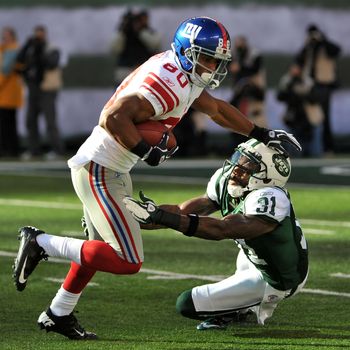 EAST RUTHERFORD, NJ - DECEMBER 24: Victor Cruz #80 of the New York Giants breaks the tackle attempt of Antonio Cromartie #31 of the New York Jets during the first half on December 24, 2011 at MetLife Stadium in East Rutherford, New Jersey. (Photo by Christopher Pasatieri/Getty Images)