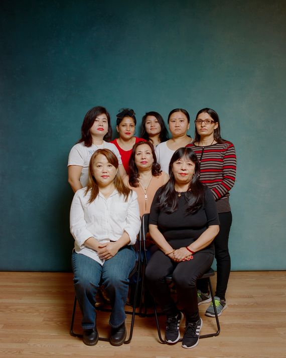 A group of eight South Asian women, who are organizing nail salon workers with the Queens-based community group Adhikaar, pose for a photo in their office