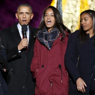 U.S. President Obama sings carols along with singer Blacc, actress Witherspoon and his daughters during the National Christmas Tree Lighting and Pageant of Peace ceremony in Washington