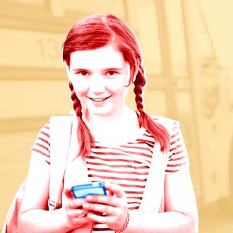  Portrait of schoolgirl holding smart phone. 