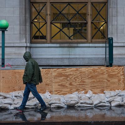NEW YORK, NY - OCTOBER 29: A man walks past a barricaded subway entrance near Battery Park during the arrival of Hurricane Sandy on October 29, 2012 in New York City. The core of Sandy's force is supposed to hit the New York area Monday night. (Photo by Andrew Burton/Getty Images)