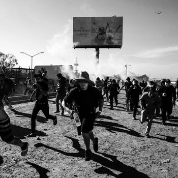 Asylum-seekers running from tear gas.