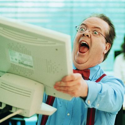Surprised Businessman Holding a Computer Monitor in the Office --- Image by ? 13/Flying Colours Ltd/Ocean/Corbis