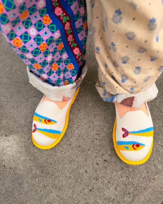 Looking down at a child's two feet in a pair of Rothy’s sardine-adorned Mini Loafers for Kids.