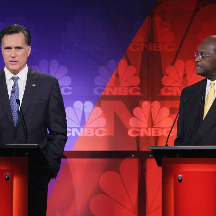 ROCHESTER, MI - NOVEMBER 09: Former CEO of Godfather's Pizza Herman Cain (R) looks on as former Massachusetts Gov. Mitt Romney speaks during a debate hosted by CNBC and the Michigan Republican Party at Oakland University on November 9, 2011 in Rochester, Michigan. The debate is the first meeting of the eight GOP presidential hopefuls since allegations of sexual impropriety have surfaced against front-runner Herman Cain. (Photo by Scott Olson/Getty Images)