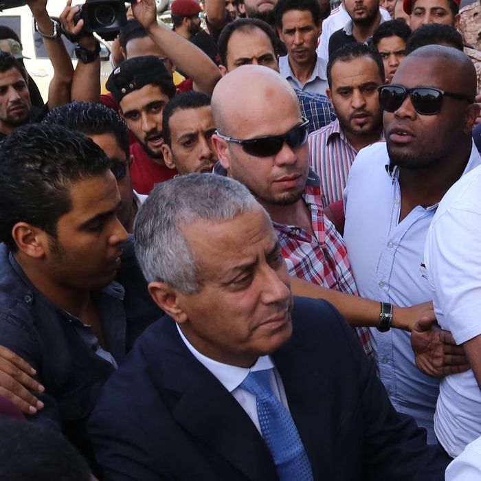 Libyan Prime Minister Ali Zeidan (C) arrives at the government headquarters in Tripoli on October 10, 2013 shortly after he was freed from the captivity of militiamen who had held him for several hours. Gunmen seized Zeidan from a hotel, where he resides, in the Libyan capital and held him for several hours before he was freed, in the latest sign of Libya's lawlessness since Moamer Kadhafi was toppled in 2011.