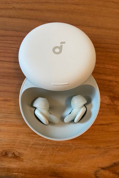 A pair of earbuds in a case on table.
