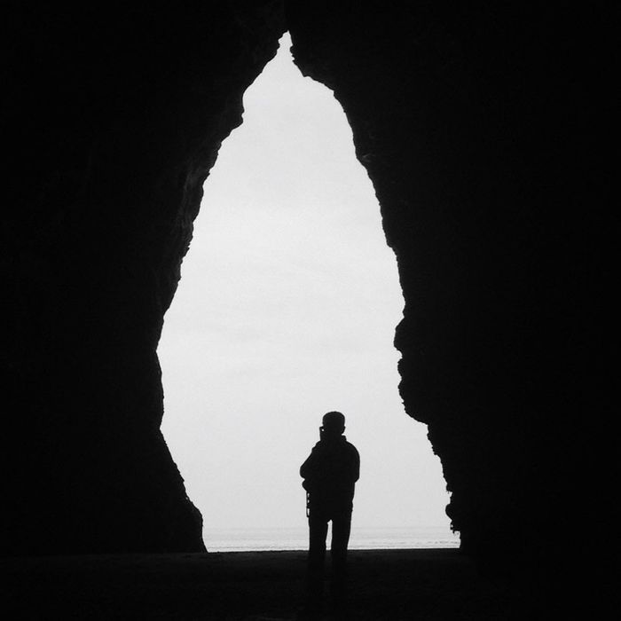 Silhouette On Boat In Cave Entrance