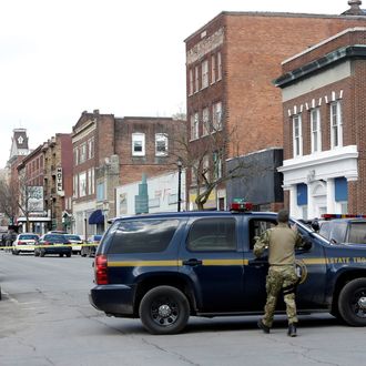 Law enforcement officers block off Main Street in Herkimer, N.Y., while searching for a suspect in two shootings that killed four and injured at least two on, Wednesday, March 13, 2013. Authorities were looking for 64-year-old Kurt Meyers, said Herkimer Police Chief Joseph Malone. Officials say guns and ammunition were found inside his Mohawk apartment after emergency crews were sent to a fire there Wednesday morning. (AP Photo/Mike Groll)