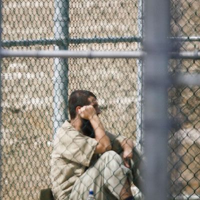 A detainee sits inside an outdoor recreation arear at Camp V, a maximum security part of Camp Delta 05 December 2006 at the US Naval Base in Guantanamo, Cuba. Approximately 445 enemy combatants from al Qaeda and the Taliban are in various security levels of lock-up in Camp Delta here by a US Joint Task Force.