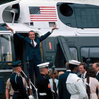 Pres. Richard Nixon raising hands w. trademark V signs in doorway of helicopter after leaving White House following his resignation over the Watergate scandal, 9th August 1974.