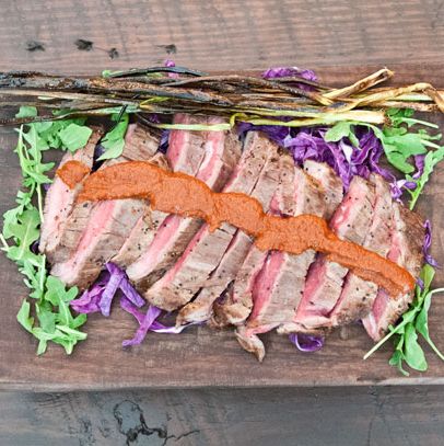 Grilled hanger steak with grilled scallions and romesco sauce.