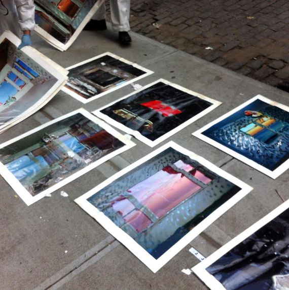 Wrinkled photographs damaged by water laid on a sidewalk.