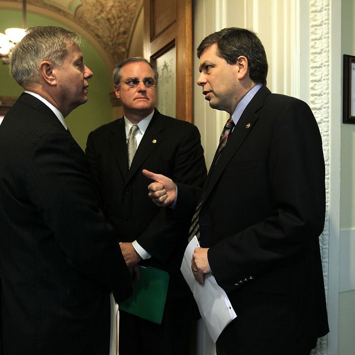 U.S. Sen. Lindsey Graham (R-SC) (L) and Sen. Mark Pryor (D-AR) (2nd L) listen to Sen. Mark Begich (D-AK) (R) prior to a news conference March 6, 2013 on Capitol Hill in Washington, DC. The senators held a news conference on legislation to prevent gun violence. 