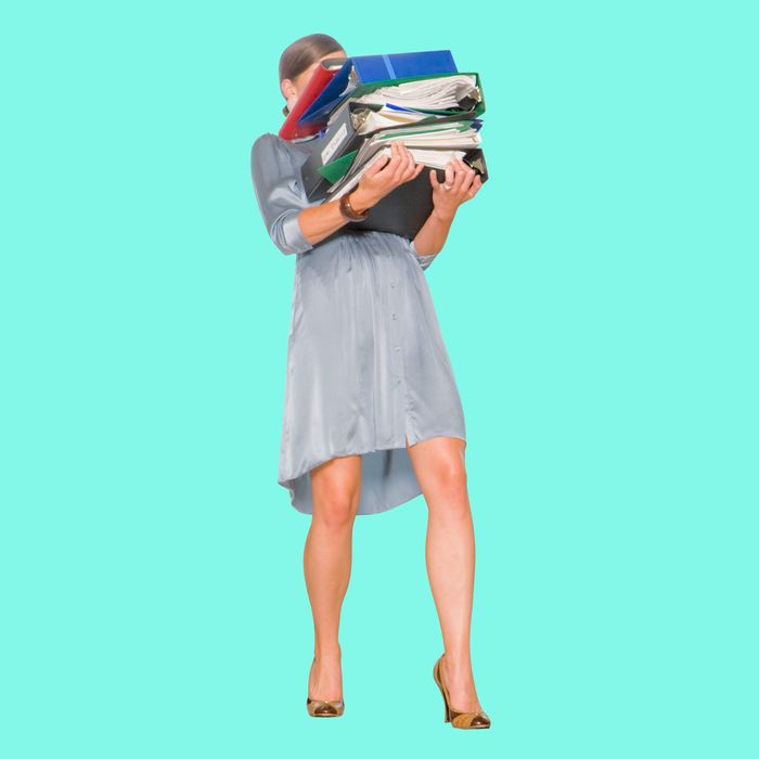 Businesswoman holding stack of binders