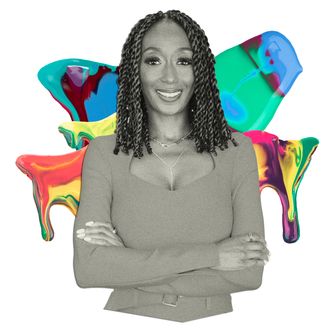 A black woman with shoulder length dark hair smiles for a portrait.