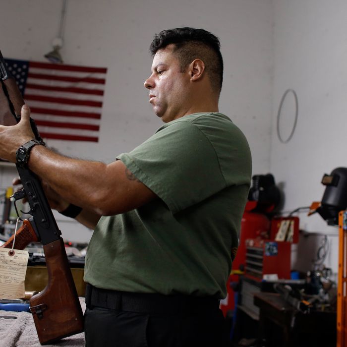 Milton Gonzalez, 46, an employee of Nebulous Ordnance, adjusts the springs of the safety on a RPK rifle, Tuesday, April 9, 2013, in Miami, Florida.