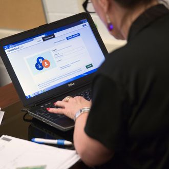 Marketplace guide Sharon Hamby works on the Healthcare.gov federal enrollment website as she helps a resident sign up for a health insurance plan under the Affordable Care Act at an enrollment event in Milford, Delaware, U.S., on Thursday, March 27, 2014. Six million Americans have signed up for private health plans under Obamacare, President Barack Obama said, a symbolic milestone for a government that has struggled to get the law off the ground. Photographer: Andrew Harrer/Bloomberg via Getty Images