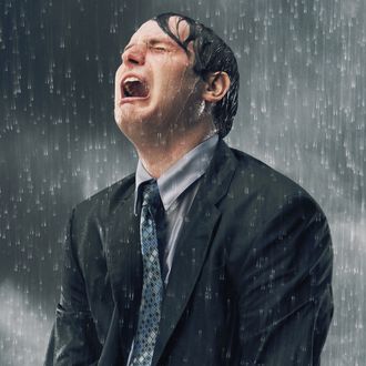 Businessman crying in rain