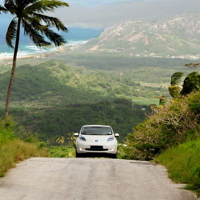 An electric vehicle drives through Cherry Tree Hill, Barbados.