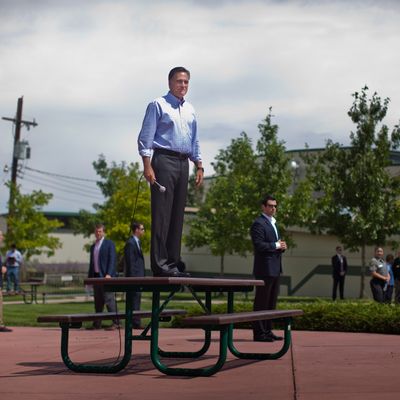 Surrounded by Secret Service, Republican Presidential candidate Mitt Romney hops on a picnic table to address a crowd gathering outside the Jefferson County Fairgrounds building in Golden, Colorado, on Thursday August 2, 2012. 