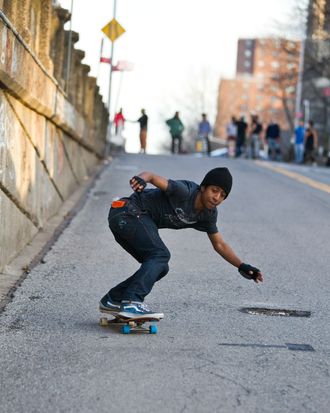 Young male skateboarder on urban street.