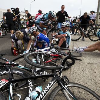 Brazil's Murilo Antoniobil Fischer (C-L), Germany's Tony Martin (C), and France's Tony Gallopin (R) sit on the ground after a fall during the 213 km first stage of the 100th edition of the Tour de France cycling race on June 29, 2013 between Porto-Vecchio and Bastia, on the French Mediterranean Island of Corsica. 