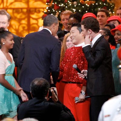 WASHINGTON, DC - DECEMBER 9: (AFP OUT) U.S. President Barack Obama shakes hands with South Korean musician PSY (C), next to host Conan O'Brien (L) and performer Scotty McCreery (R) during the 