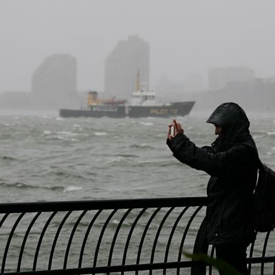 A woman uses her mobile phone to photograph New York Harbor at Battery Park, at the southern tip of Manhattan, Monday, Oct. 29, 2012. Defiant New Yorkers jogged, pushed strollers and took snapshots of churning New York Harbor on Monday, trying to salvage normal routines in a city with no trains, schools and an approaching mammoth storm.
