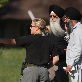OAK CREEK, WI - AUGUST 05: A police officer directs people near the Sikh Temple of Wisconsin where at least one gunman stormed the mass and opened fire August, 5, 2012 Oak Creek, Wisconsin. At least six people are reported to have been killed when a shooter, who was shot dead by a police officer, opened fire on congregants in the Milwaukee suburb. (Photo by Scott Olson/Getty Images)