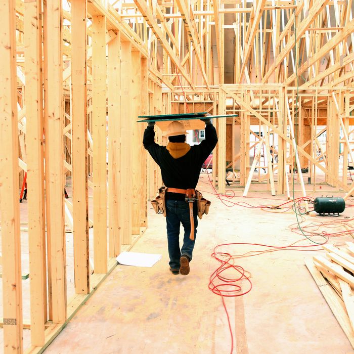 A contractor carries boards through a house under construction in Lancaster, South Carolina.