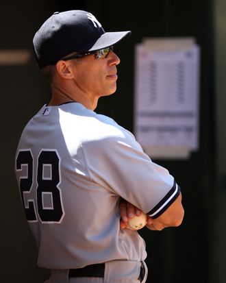 Manager Joe Girardi #28 of the New York Yankees watches from the dugout during the game against the Oakland Athletics