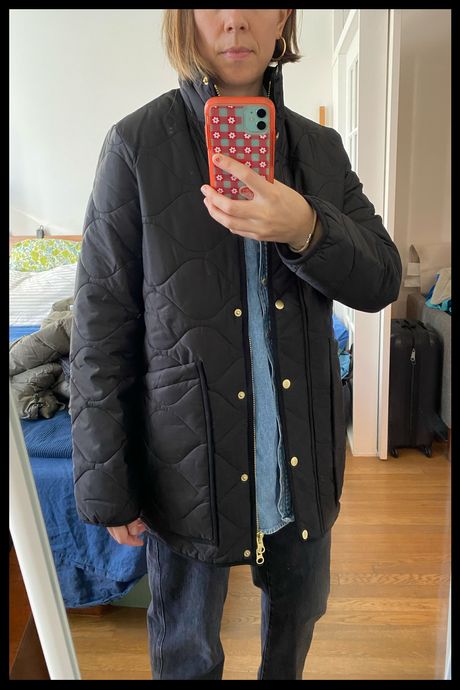Photo of Strategist senior writer Liza Corsillo wearing Quince’s Women's Featherless Quilted Long Puffer Jacket in black.