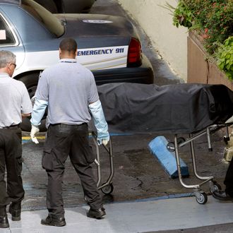 Miami-Dade morgue workers carry out a body out at the scene of a fatal shooting in Hialeah, Fla., Saturday, July 27, 2013. A gunman holding hostages inside the apartment complex killed six people before being shot to death by a SWAT team that stormed the building early Saturday following an hours-long standoff, police said. (AP Photo/Alan Diaz)