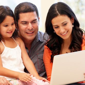 Hispanic family with laptop at home.