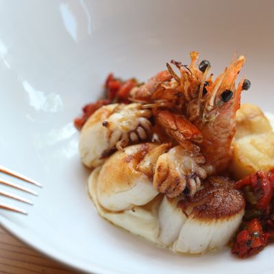 Plancha Marina with scallop, seppiolini, head-on shrimp, monkfish, roasted peppers, and aïoli.