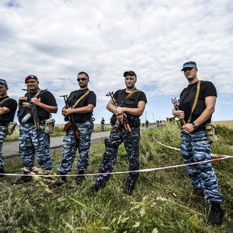 Armed pro-Russian separatists block the way to the crash site of Malaysia Airlines Flight MH17, near the village of Grabove, in the region of Donetsk on July 20, 2014. The missile system used to shoot down a Malaysian airliner was handed to pro-Russian separatists in Ukraine by Moscow, the top US diplomat said Sunday. Outraged world leaders have demanded Russia's immediate cooperation in a prompt and independent probe into the shooting down on July 17 of flight MH17 with 298 people on board. AFP PHOTO/ BULENT KILIC