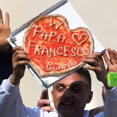 A man shows a pizza made for pope Francis during the weekly general audience in Saint Peter's square at the Vatican on March 11, 2015. 