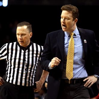 Head coach Chris Mooney of the Richmond Spiders speaks to a referee in the second half against the Charlotte 49ers during the first round of the Atlantic 10 basketball tournament at Barclays Center on March 14, 2013 in New York City.