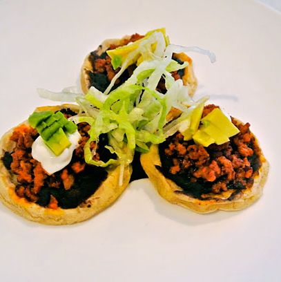 自制厚玉米粉圆饼，西班牙香肠，豆类，生菜，牛油果和奶油