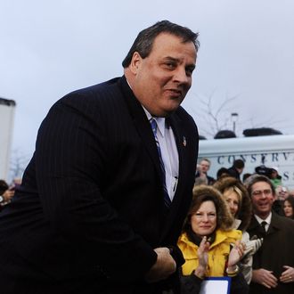 New Jersey Governor Chris Christie looks on during a campaign rally outside a grocery store in Des Moines, Iowa, on December 30, 2011. Romney on Friday ripped President Barack Obama over his annual Hawaii vacation, painting him as out of touch with Americans' economic suffering. 