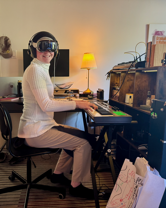 Maxine Collard at her home in San Francisco, pictured wearing an Apple Vision Pro and seated at a keyboard.