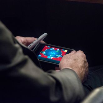 WASHINGTON, DC - SEPTEMBER 3: Senator John McCain plays poker on his IPhone during a U.S. Senate Committee on Foreign Relations hearing where Secretary of State John Kerry, Secretary of Defense Chuck Hagel, and Chairman of the Joint Chiefs of Staff General Martin Dempsey testify concerning the use of force in Syria, on Capitol Hill in Washington DC, Tuesday, September 3, 2013. (Photo by Melina Mara/The Washington Post)