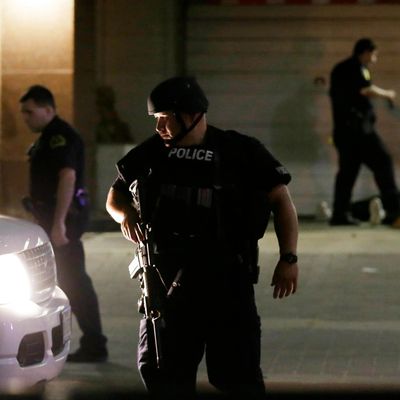 Dallas police detain a driver after several police officers were shot in downtown Dallas, Thursday, July 7, 2016. Snipers apparently shot police officers during protests and some of the officers are dead, the city's police chief said in a statement. (AP Photo/LM Otero)