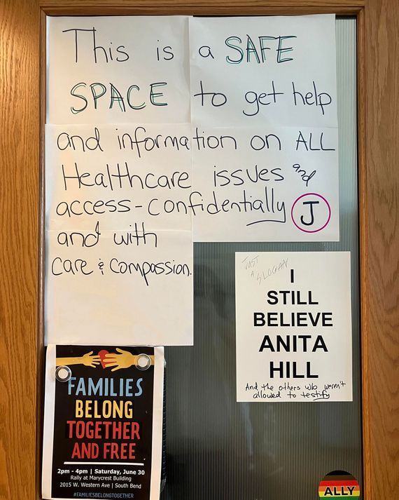 A poster on an office door reads: “This is a SAFE SPACE to get help and information on ALL Healthcare issues and access—confidentially with care and compassion.” 