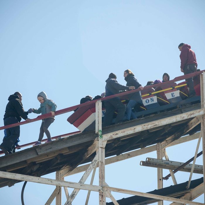 Workers assist thrill seekers on the Luna Park Coney Island Cyclone roller coaster after it got stuck on its inaugural run of the Summer 2015 season. The rescue involved walking down the ties. -- The Coney Island Cyclone roller coaster got stuck on its inaugural run of the Summer season. The train stopped just short of the initial drop. The first riders had to escorted down the landmark wooden coaster after being stuck for about 5 minutes.