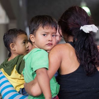 Migrants who just disembarked from a U.S. ICE bus wait for a Greyhound official to process their tickets to their next destination at a Greyhound bus station in Phoenix