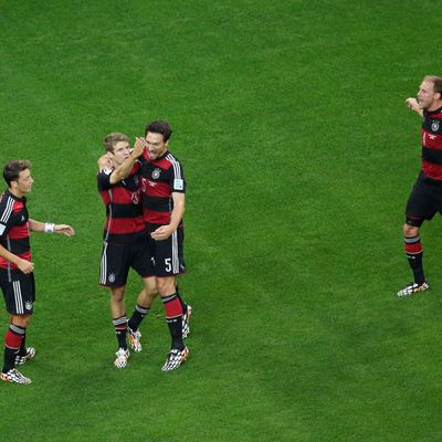 BELO HORIZONTE, BRAZIL - JULY 08: Thomas Mueller of Germany celebrates scoring his team's first goal with Mats Hummels, Mesut Oezil (L) and Benedikt Hoewedes (R) during the 2014 FIFA World Cup Brazil Semi Final match between Brazil and Germany at Estadio Mineirao on July 8, 2014 in Belo Horizonte, Brazil. (Photo by Felipe Dana - Pool/Getty Images)