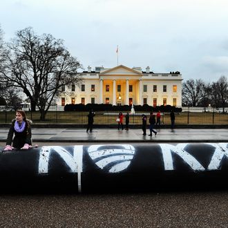 Environmental activists inflate a long balloon to mock a pipeline during a demonstration in front of the White House in Washington, DC, on February 3, 2014 to protest against the Keystone pipeline project. 